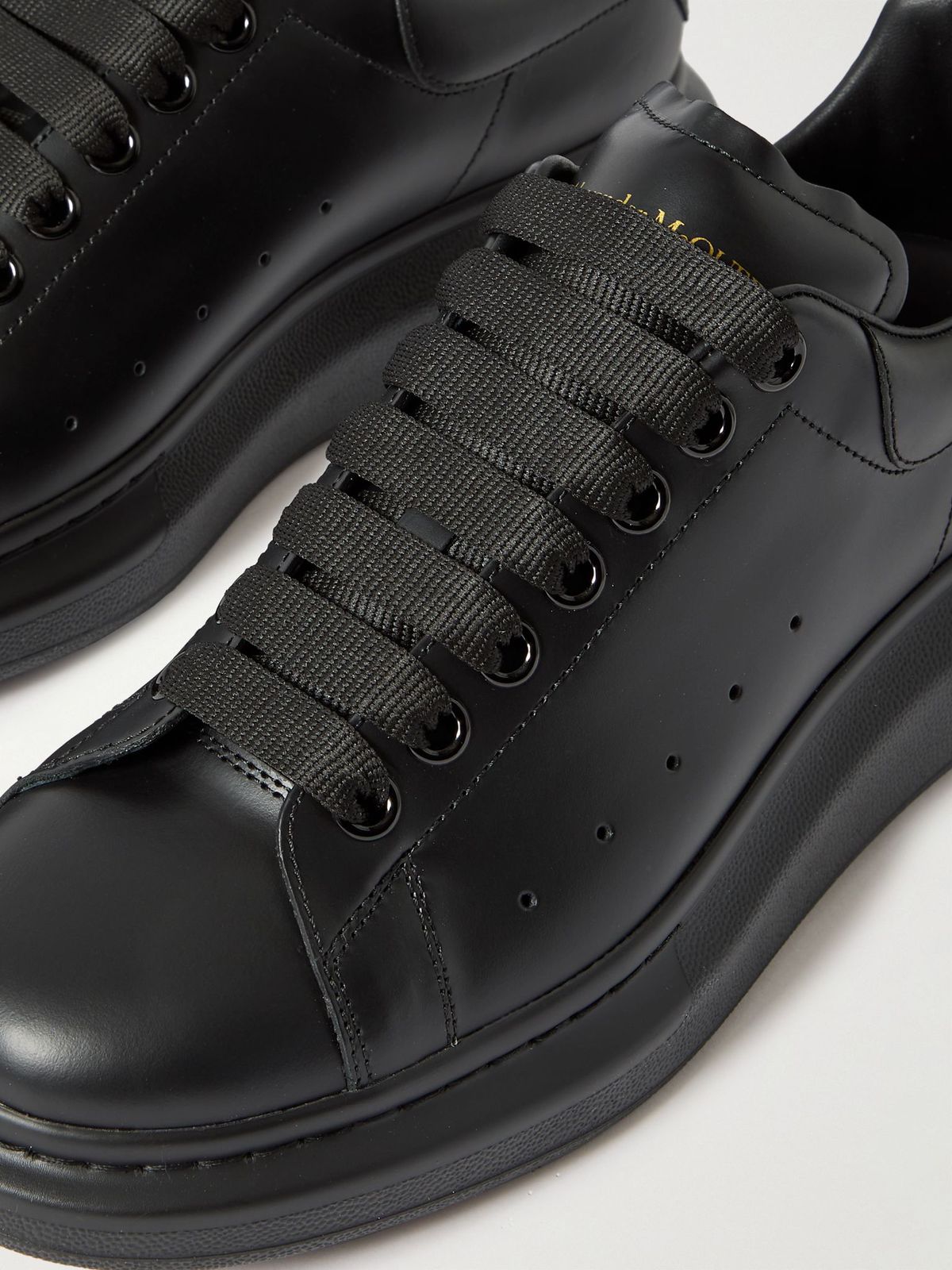 Black leather and lace details on Alexander McQueen Oversized Sneaker