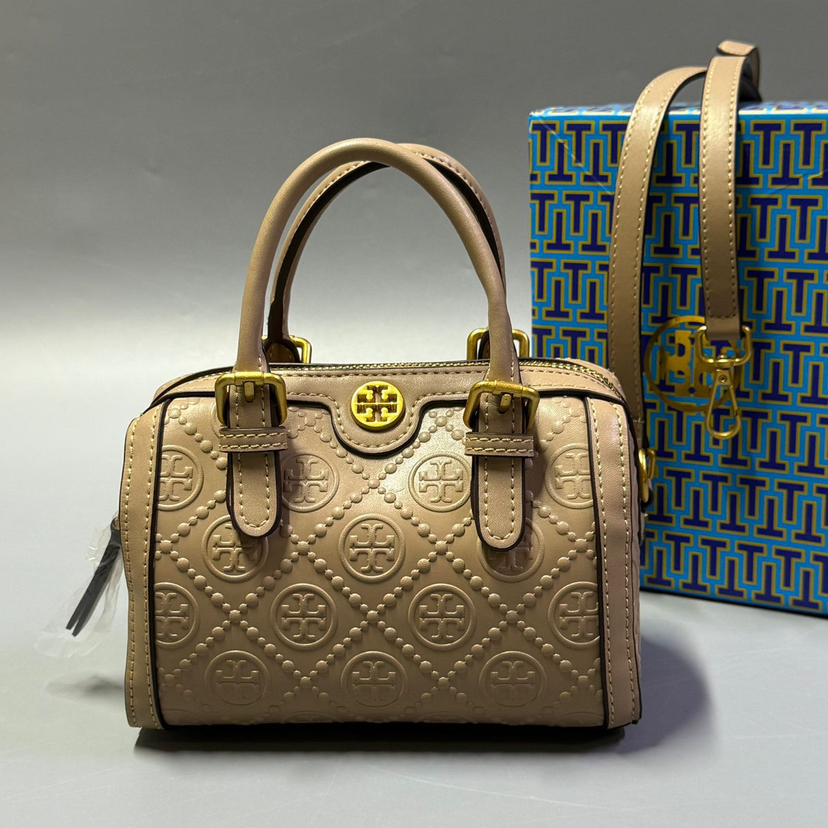 Beige Tory Burch style handbag with elegant gold detailing
