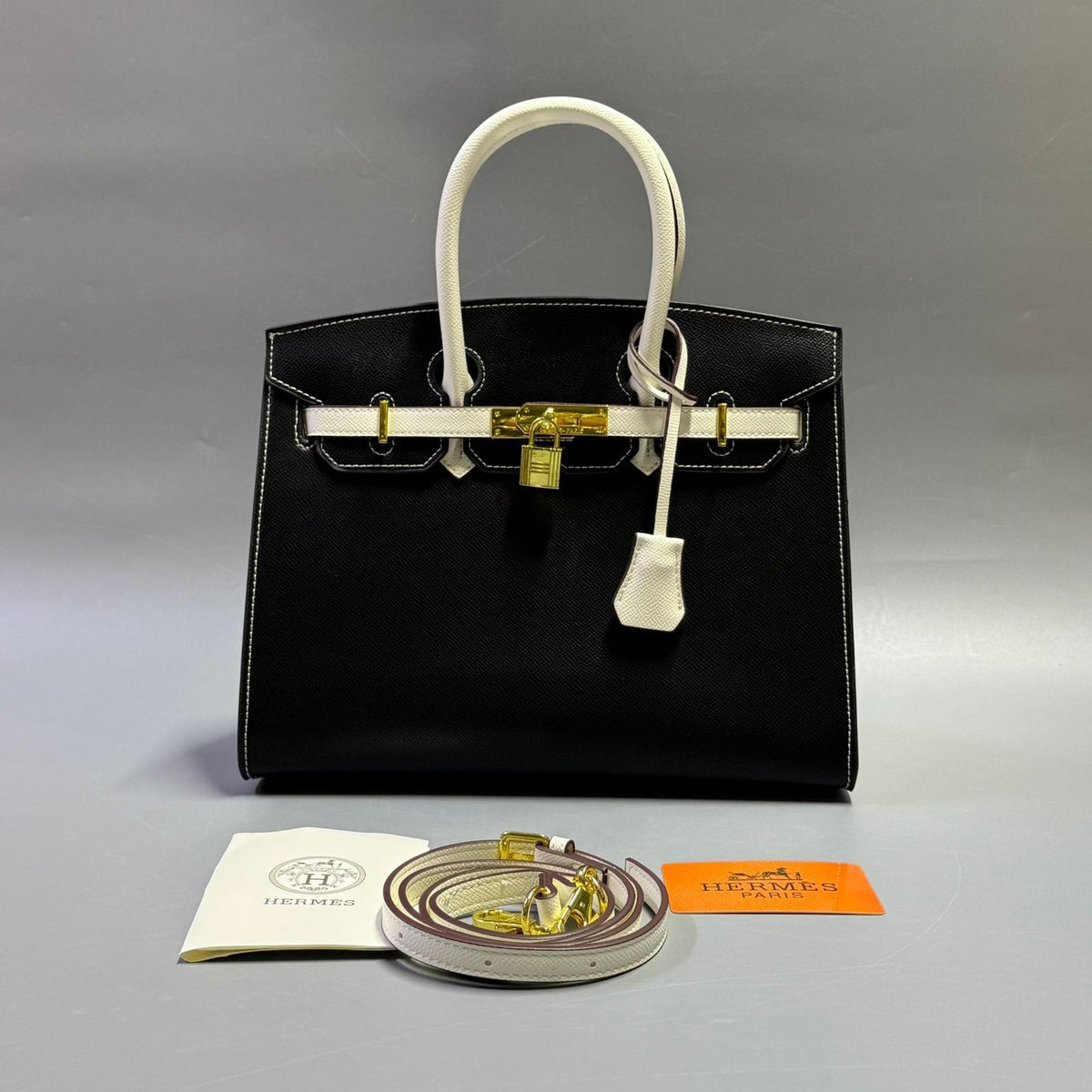 Classic black luxury leather handbag with contrasting white handles