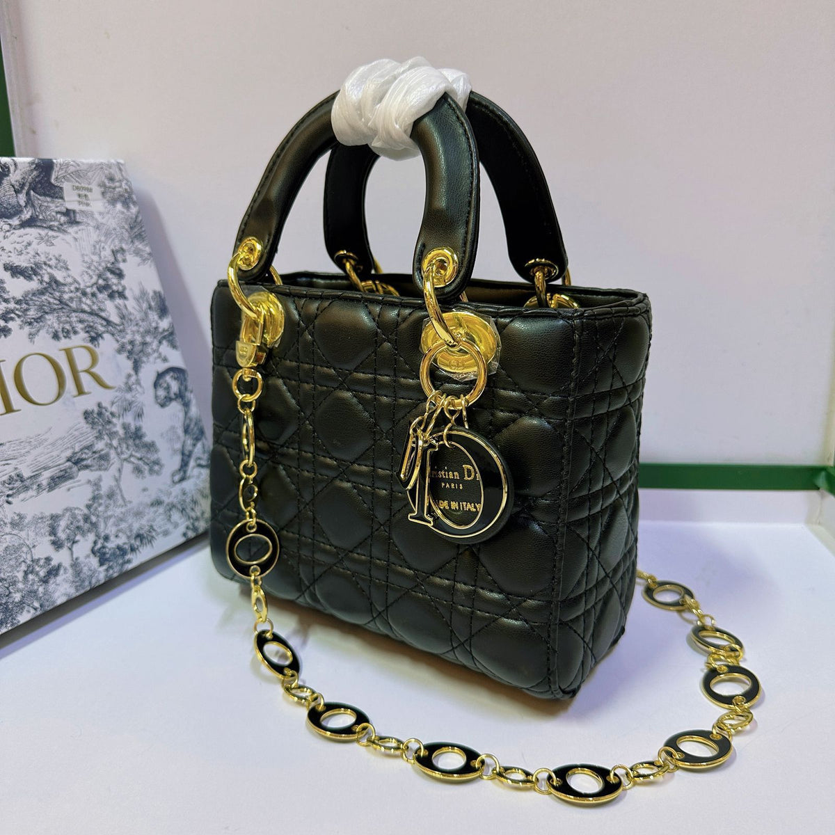 Black quilted women's handbag displayed with chain strap