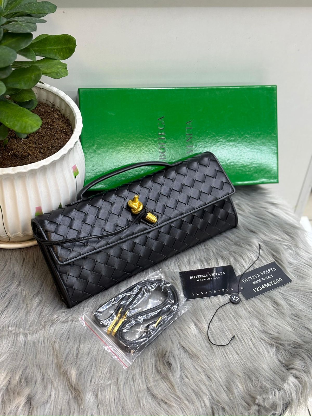 Black Bottega Veneta Intrecciato woven leather clutch with gold knot clasp