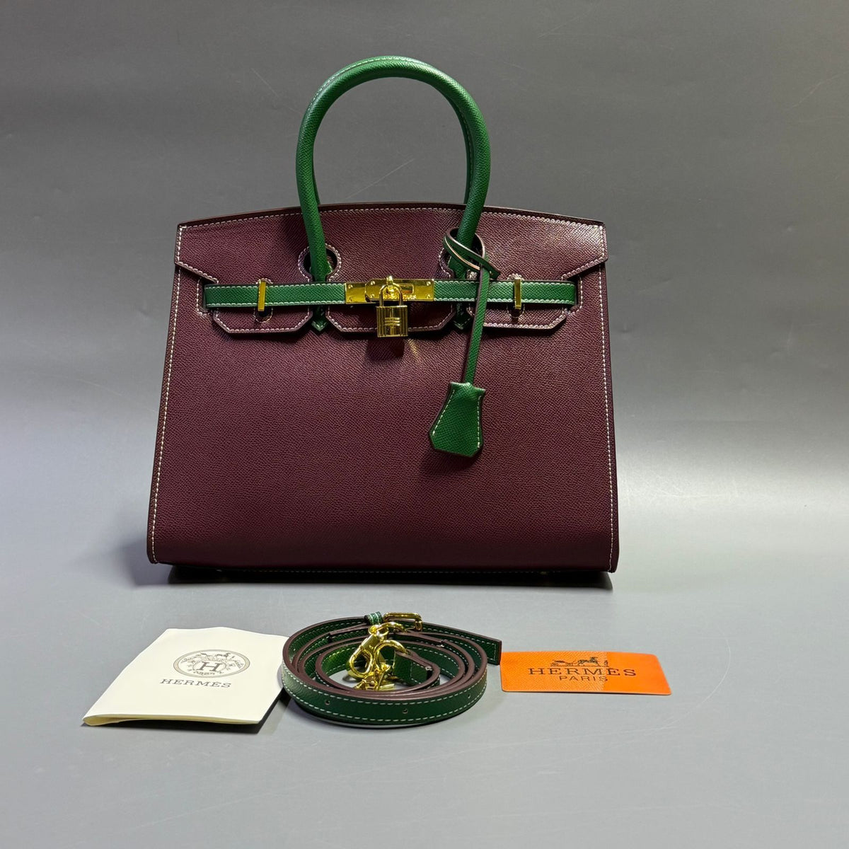 Front close up detail of burgundy and green luxury leather tote bag