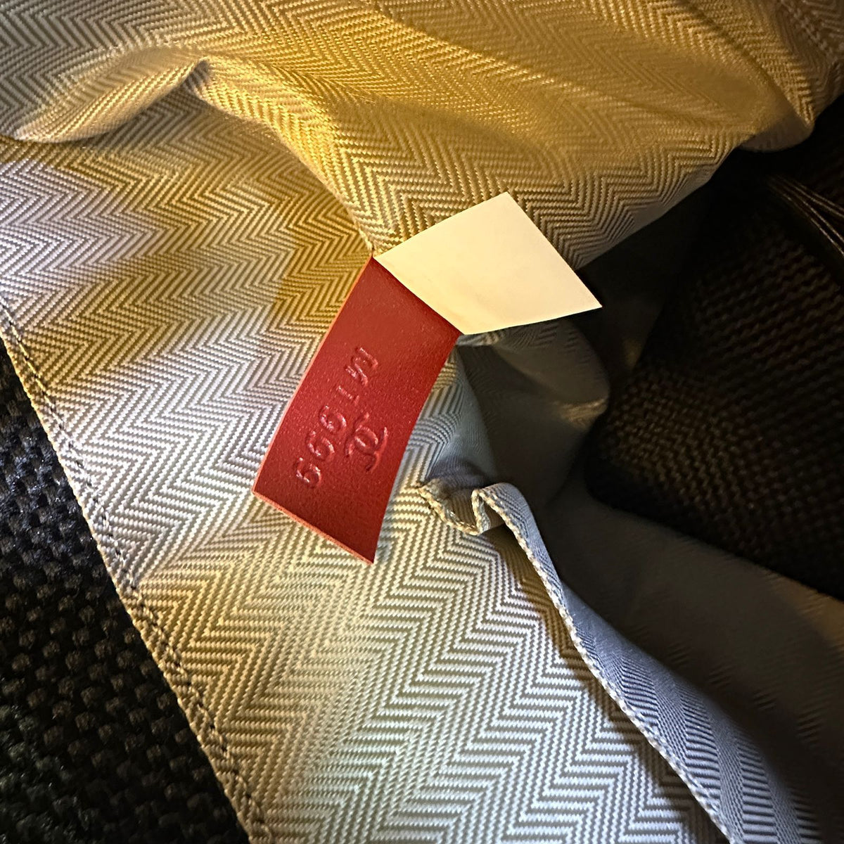 Close-up of a patterned fabric with a red label featuring text.