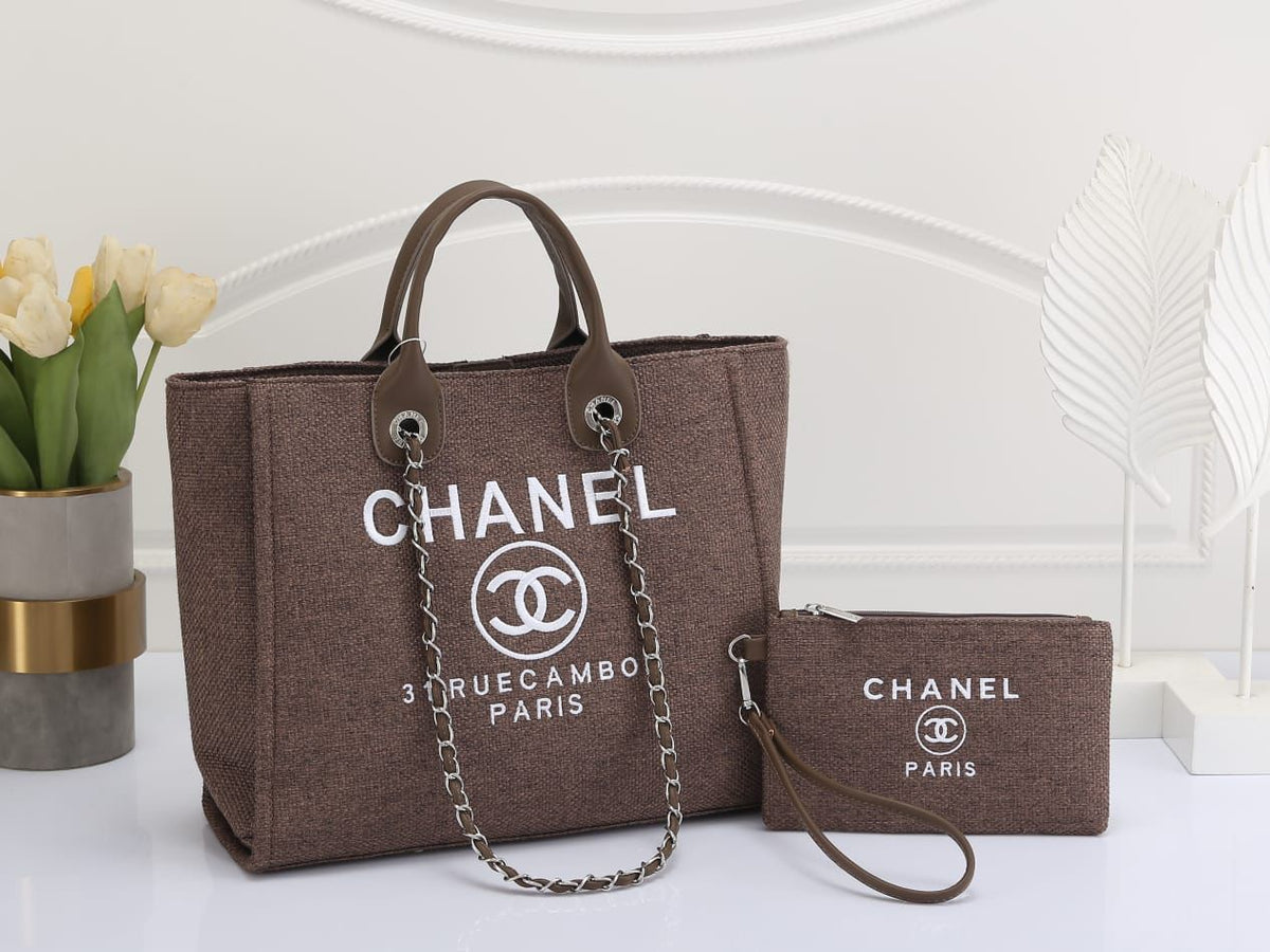 Chanel handbag and wallet set on a white surface with a blurred background