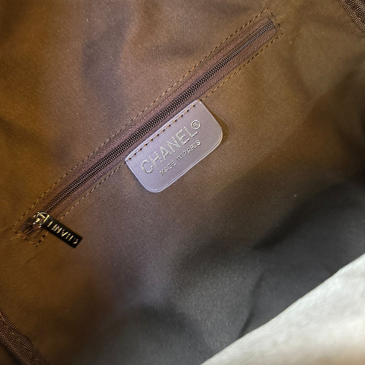 Close-up of a brown Chanel bag with a visible logo.