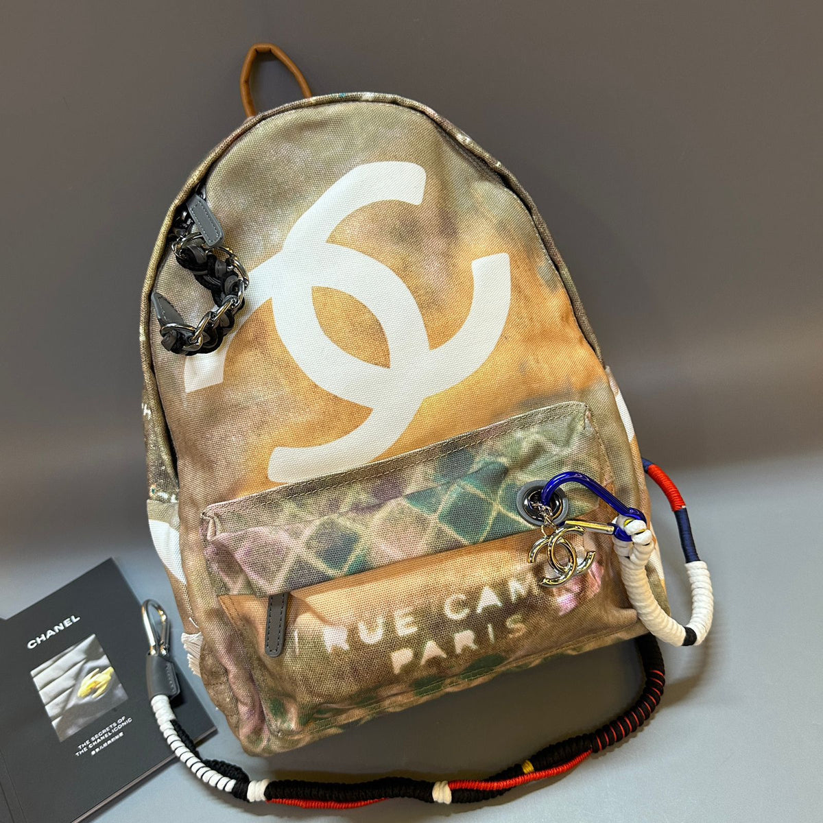 Backpack with Chanel logo and colorful strap on a gray background
