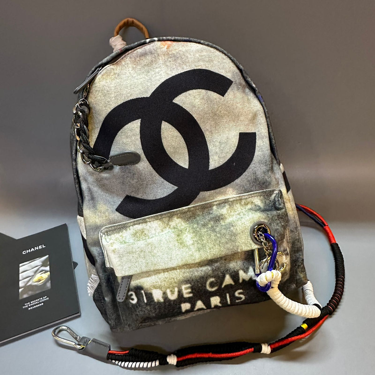 Backpack with Chanel logo and 'Rue Cam' text on a gray background