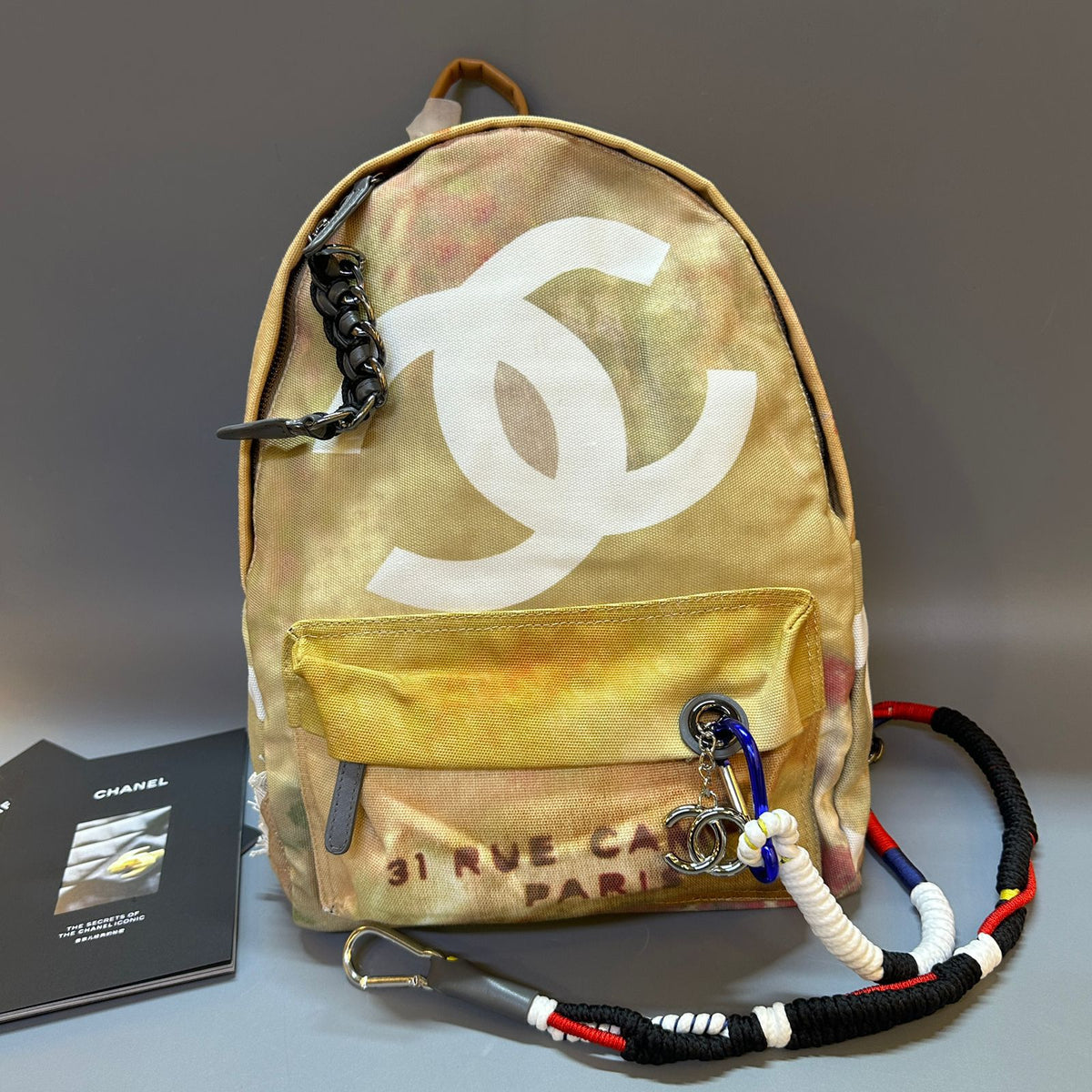 Backpack with Chanel logo and keychain on a gray background