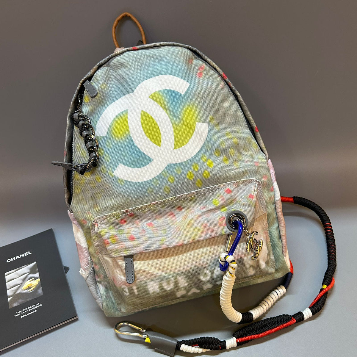 Backpack with Chanel logo and colorful design on a gray surface