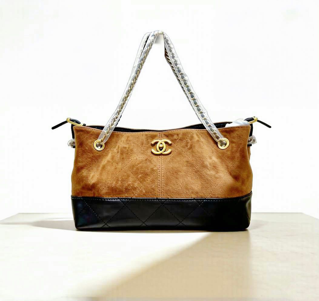 Brown and black handbag with a visible brand logo on a white background
