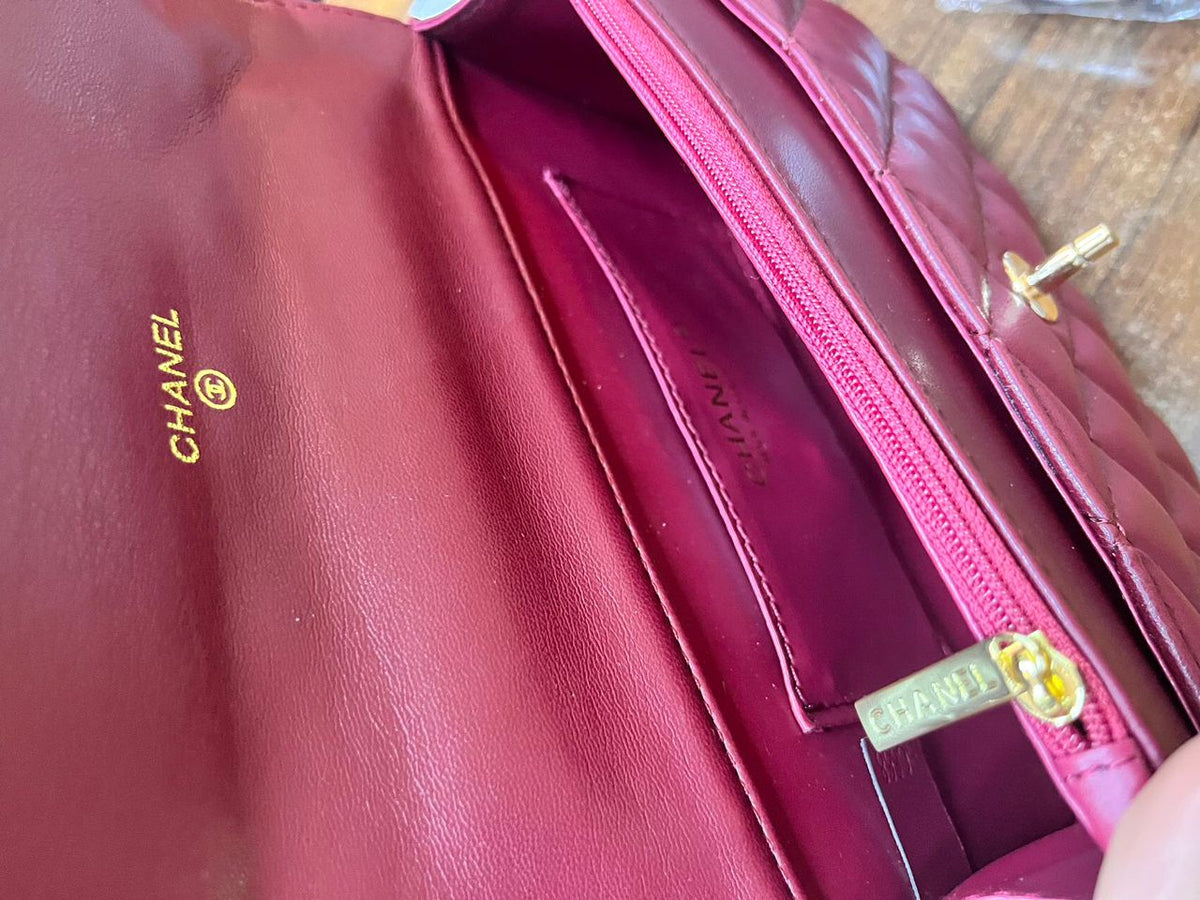 Interior view of Chanel quilted leather flap bag showing pink leather lining and zipper pocket