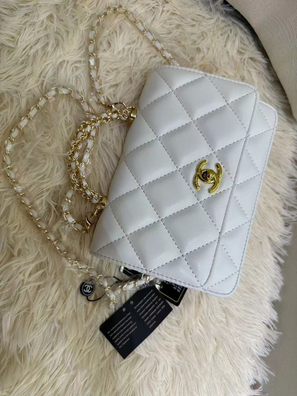 Pure white Chanel quilted leather mini flap bag with interwoven gold chain strap
