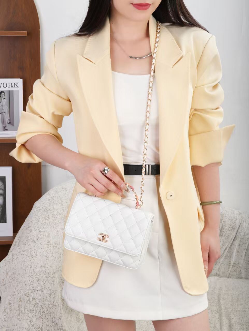 Model styled in outfit holding pure white Chanel quilted flap bag