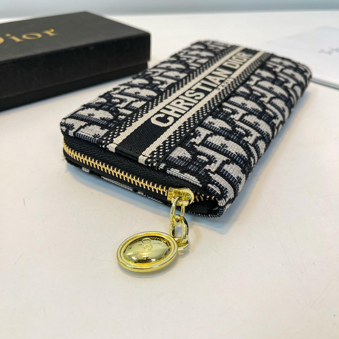 Angled view of patterned Dior zip wallet