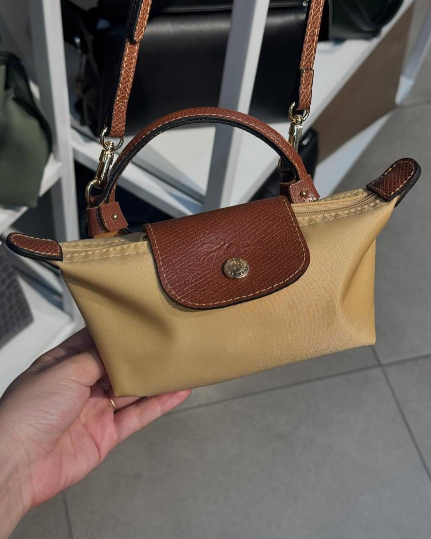 Brown Longchamp mini top-handle bag shown in hand