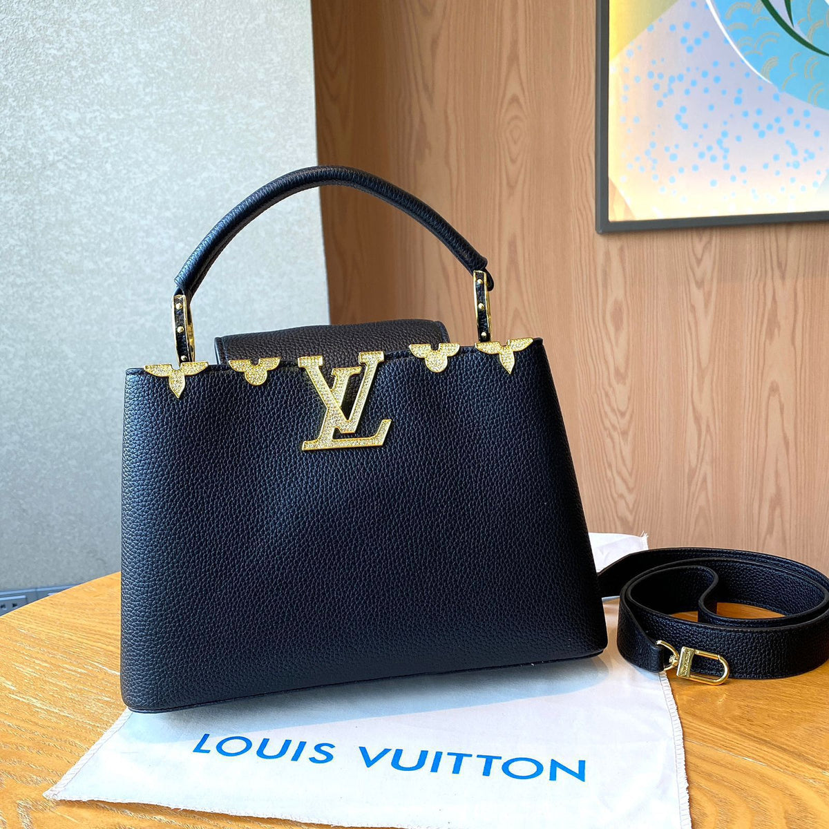 Black handbag with gold accents on a Louis Vuitton pouch