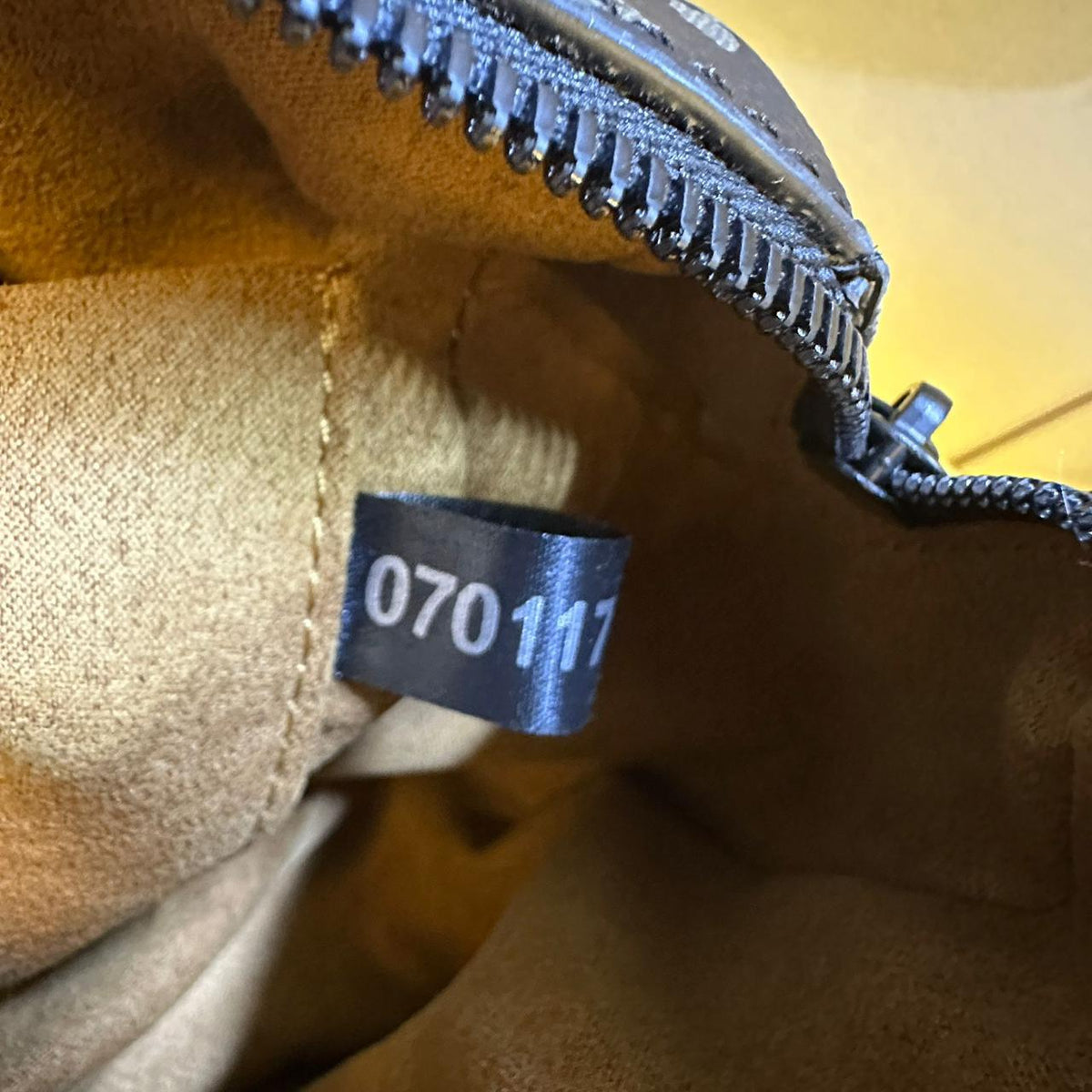 Close up of internal leather serial code tag inside Louis Vuitton bag