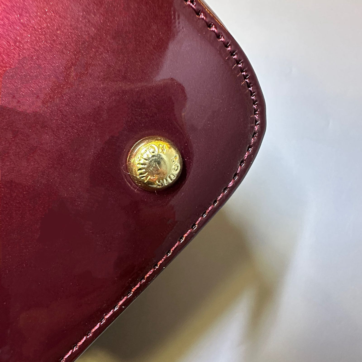 Gold hardware detail on Louis Vuitton style women's handbag