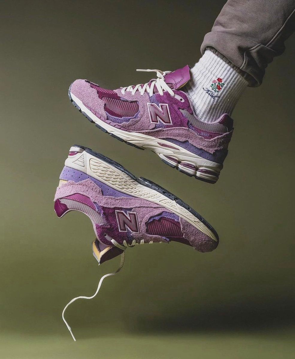New Balance 2002R pink and purple sneakers on feet