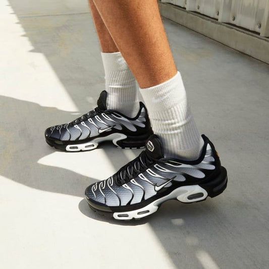 Nike Air Max Plus black and grey sneakers on feet