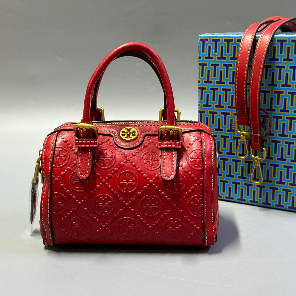 Red Tory Burch style handbag with elegant gold detailing