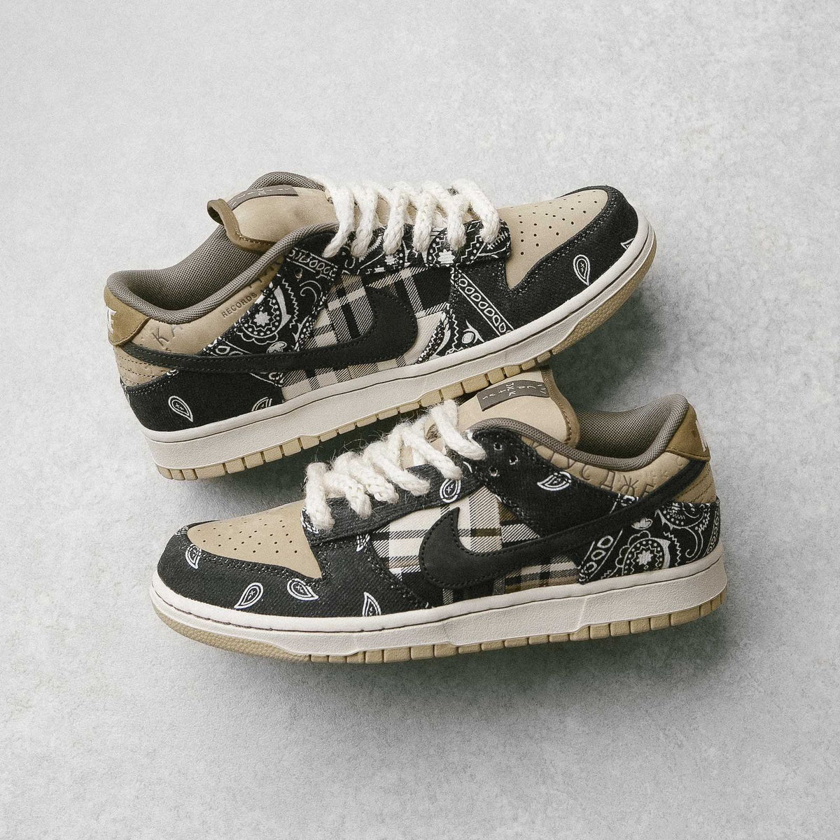 Pair of Travis Scott Dunk Low sneakers with paisley overlays