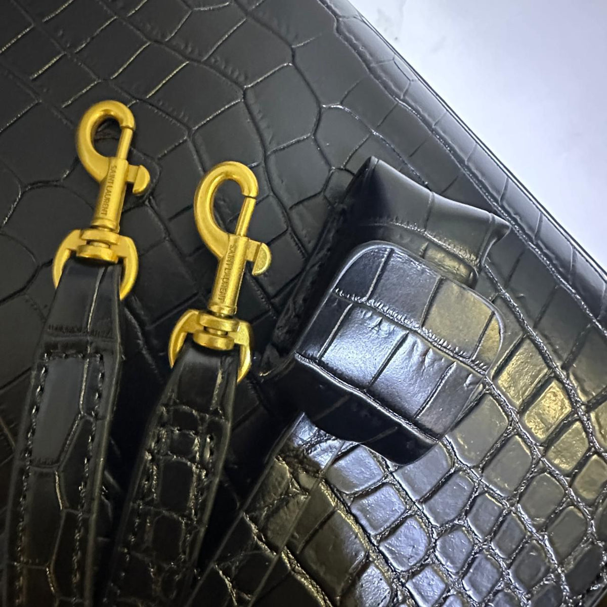 Gold hardware detail on black YSL style handbag