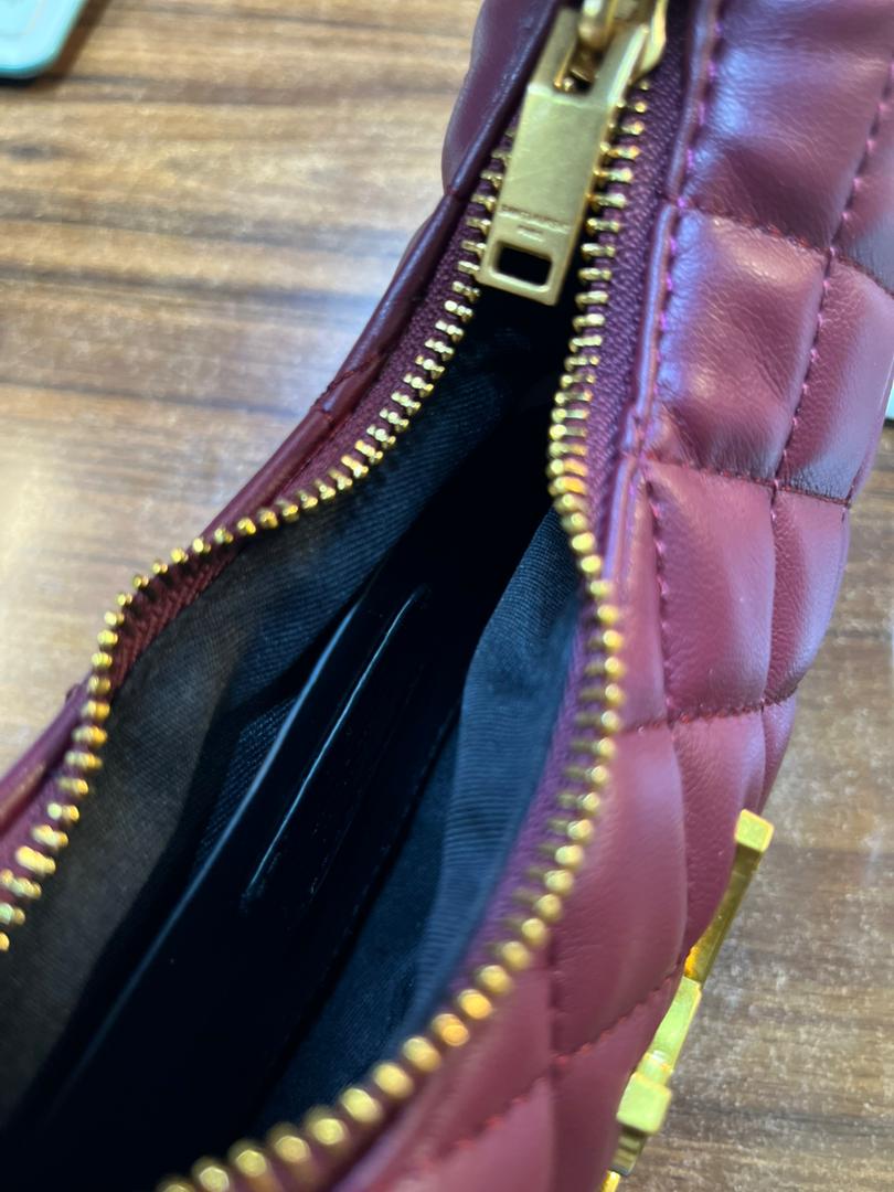 Interior zipper compartment view of YSL quilted leather burgundy hobo bag
