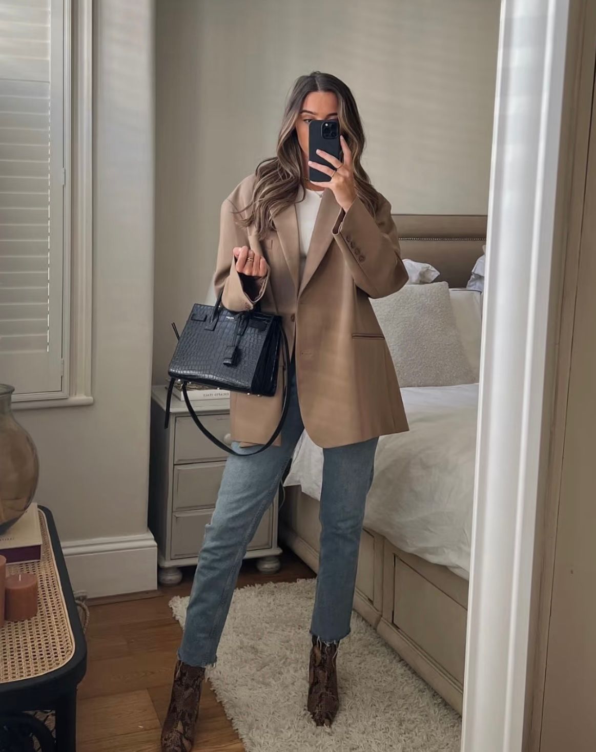 Woman carrying YSL style black women's handbag with shoulder strap
