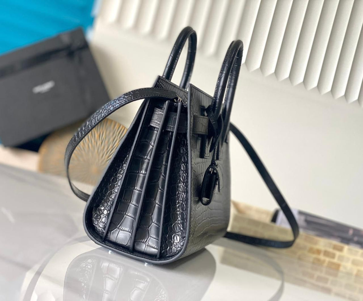 Side view of black YSL style handbag with shoulder strap