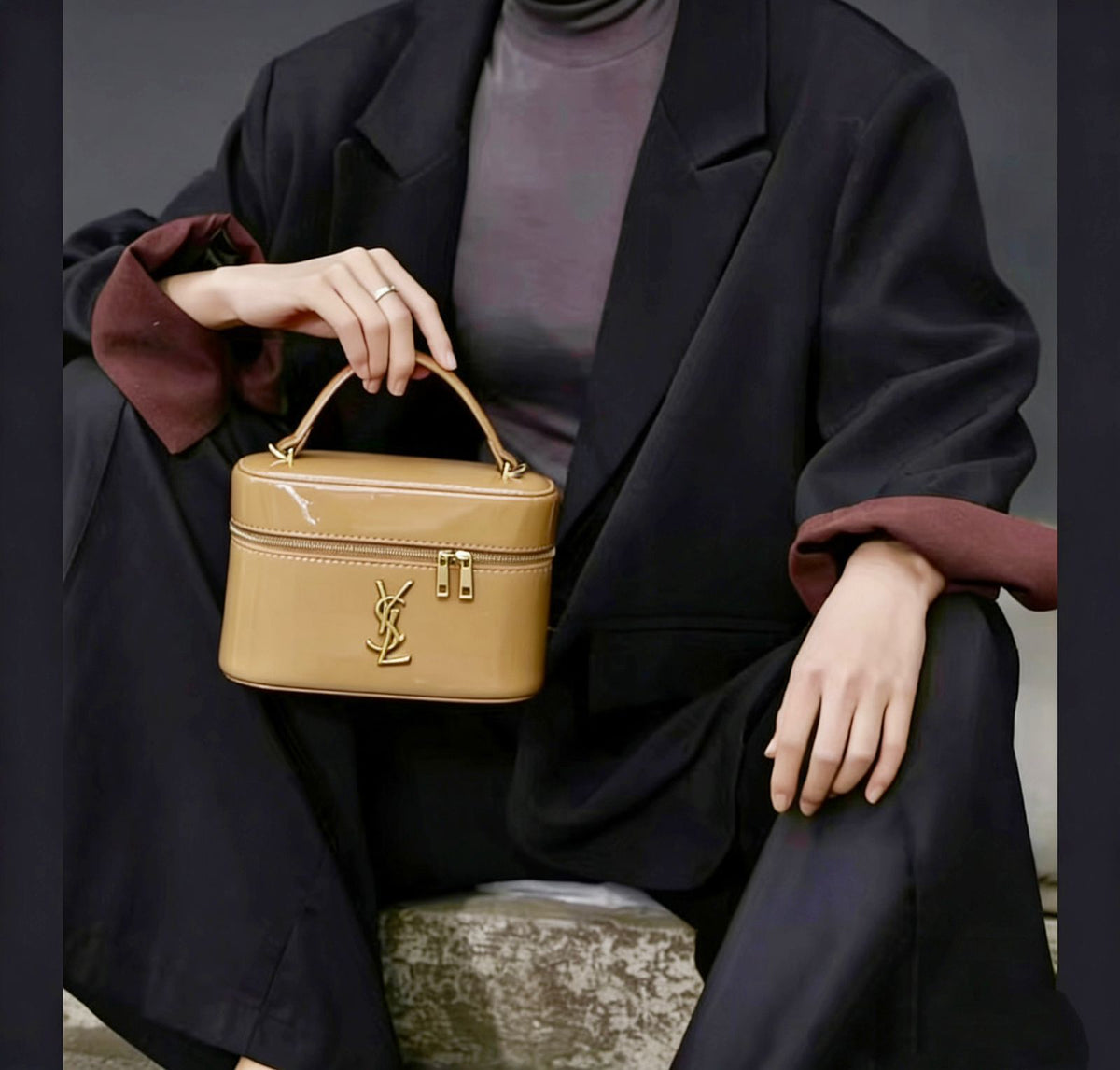 Model carrying tan YSL women leather vanity case bag with top handle